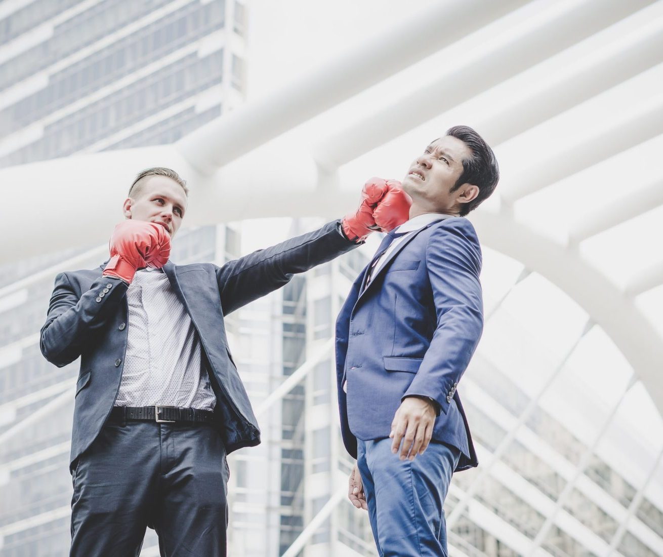 businessman-with-red-boxing-gloves-ready-fight-his-coworker-min businessman-with-red-boxing-gloves-ready-fight-his-coworker-min